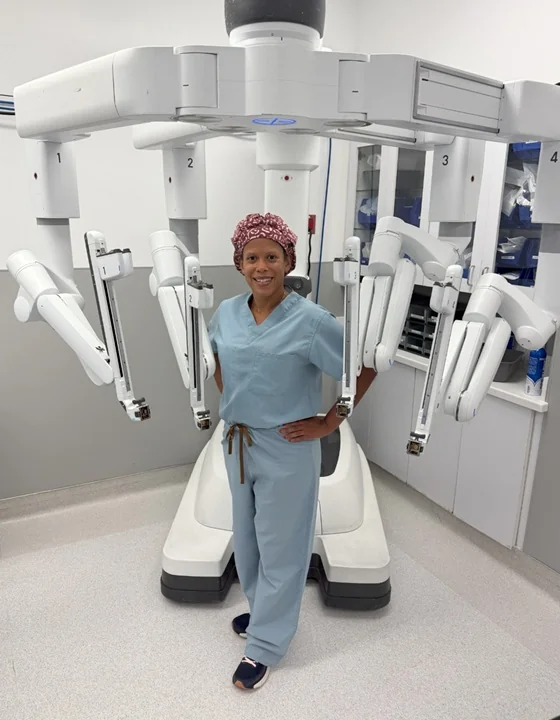 Dr. Melinda Nicole Lamb standing with the da Vinci robotic surgical system